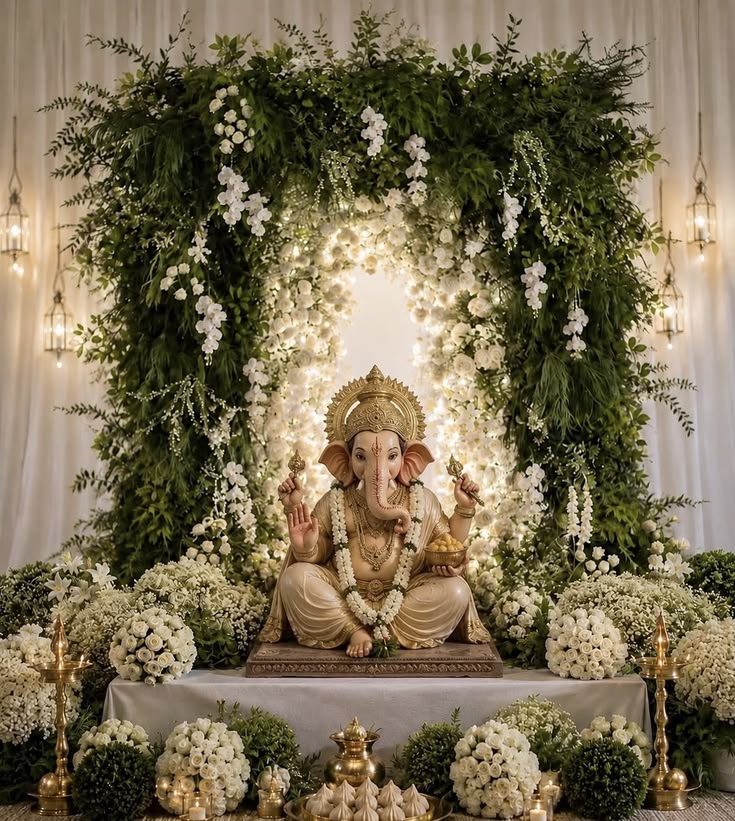 Gowri Ganesha decoration with greenery arch, white flowers and festive pooja setup